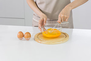 Manos batiendo huevos